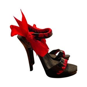Black patent leather heels with red satin, ribbon and tie.